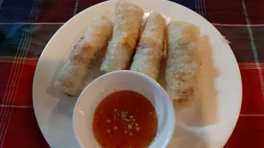 Kareli masa örtüsünün üzerinde biber soslu fırında börek.