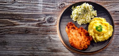 Patates ve lahana ile servis edilen ekmek kırıntılarıyla kaplı tavuk pirzolası.