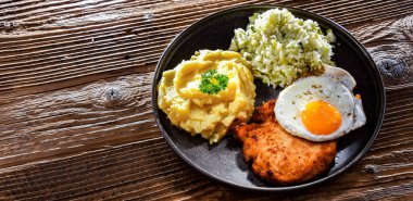 Kızarmış tavuk yumurtası, patates ve lahana ile servis edilen kızarmış tavuk pirzolası.