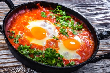 Shakshouka tabağı dökme demir bir tavada.