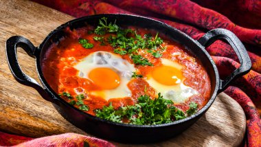 Shakshouka tabağı dökme demir bir tavada.