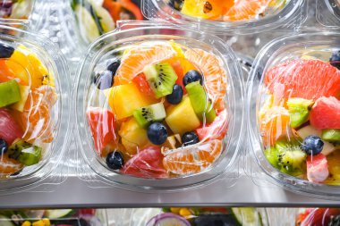 Plastic boxes with pre-packaged fruit salads, put up for sale in a commercial refrigerator