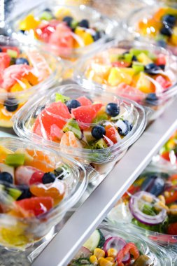 Plastic boxes with pre-packaged fruit salads, put up for sale in a commercial refrigerator