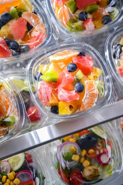 stock image Plastic boxes with pre-packaged fruit salads, put up for sale in a commercial refrigerator