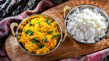 Hint karahi kaplarında servis edilen pirinçli körili tavuk..