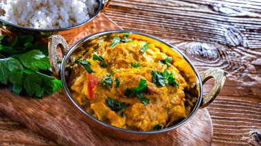 Hint karahi kaplarında servis edilen pirinçli körili tavuk..