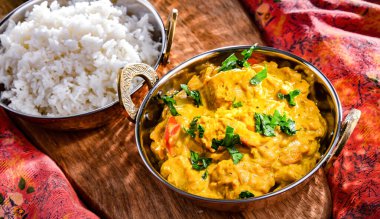 Hint karahi kaplarında servis edilen pirinçli körili tavuk..