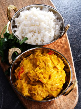 Hint karahi kaplarında servis edilen pirinçli körili tavuk..