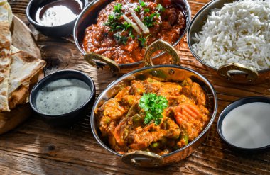 Hot madras paneer and vegetable masala with basmati rice served in original indian karahi pots.