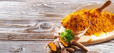 Bir kase zemin zerdeçal ve taze rhizomu ile kompozisyon.