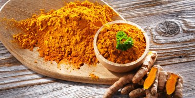 Bir kase zemin zerdeçal ve taze rhizomu ile kompozisyon.