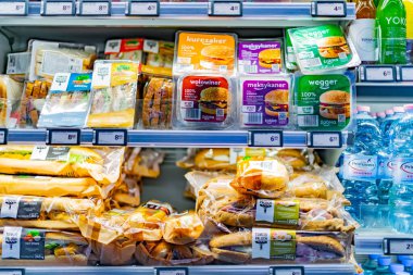 POZNAN, POL - 12 MAR 2022: Bir marketteki ticari buzdolabında sergilenen önceden paketlenmiş yiyecek ve içecekler