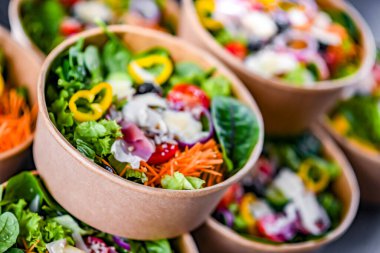 Yuvarlak karton kutular ve önceden paketlenmiş sebze salataları satışa hazır.