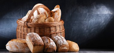 Wicker basket with bakery products including loaves of bread and rolls
