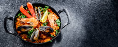Seafood paella served in a cast iron pan.