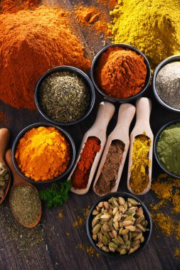 Ahşap mutfak masasında değişik baharatlar var..