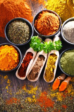 Ahşap mutfak masasında değişik baharatlar var..