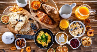 Breakfast served with coffee, orange juice, scrambled eggs, cereals, pancakes and croissants.