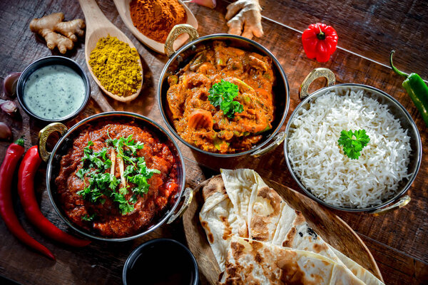Горячие мадрасы панир и овощная масала с рисом басмати подаются в оригинальных индийских кастрюлях карахи.