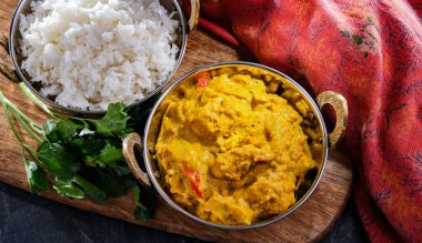 Hint karahi kaplarında servis edilen pirinçli körili tavuk..