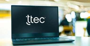 POZNAN, POL - MAR 8, 2023: TTEC Holding 'in logosunu gösteren dizüstü bilgisayar, merkezi Englewood, Colorado, ABD' de bulunan bir müşteri deneyimi teknoloji ve hizmet şirketi