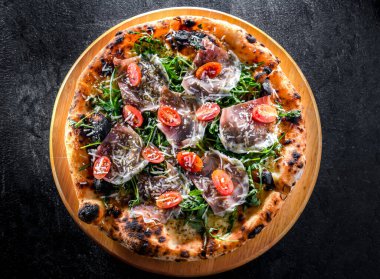 Pizza Italiana jambon, peynir, domates ve roka ile servis edilir..