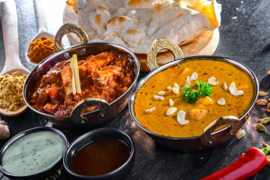 Hint yemekleri ile kompozisyon: medras paneer, palak paneer ve shahi paneer ile orijinal Hint karahi kaplarında servis edilen basmati pilavı.