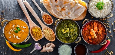 Hint yemekleri ile kompozisyon: medras paneer, palak paneer ve shahi paneer ile orijinal Hint karahi kaplarında servis edilen basmati pilavı.