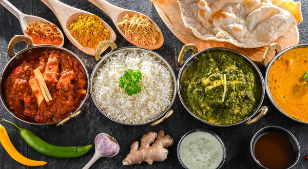 stock image Composition with indian dishes: madras paneer, palak paneer and shahi paneer with basmati rice served in original indian karahi pots.