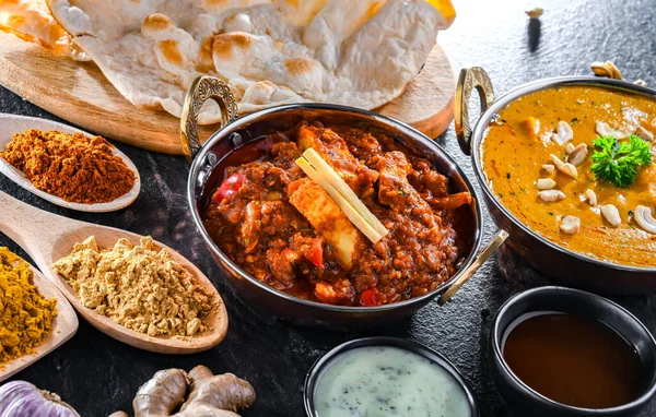 stock image Composition with indian dishes: madras paneer, palak paneer and shahi paneer with basmati rice served in original indian karahi pots.