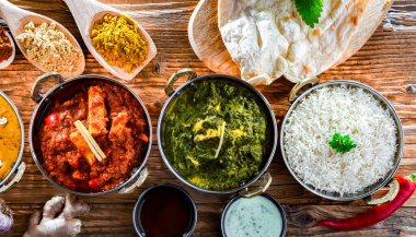 Hint yemekleri ile kompozisyon: medras paneer, palak paneer ve shahi paneer ile orijinal Hint karahi kaplarında servis edilen basmati pilavı.