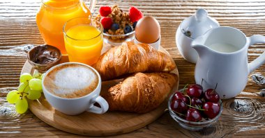 Kahvaltının yanında kahve, portakal suyu, kruvasan ve yumurta var..