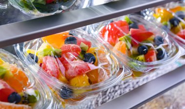 Plastic boxes with pre-packaged fruit salads, put up for sale in a commercial refrigerator