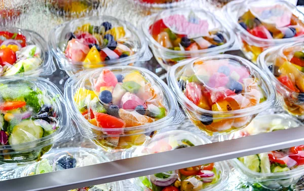 市販の冷蔵庫で販売のために置く パッケージ化されたフルーツサラダ付きのプラスチックボックス — ストック写真