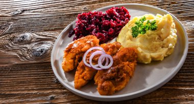 Patates ve pancar ile servis edilen kızarmış tavuk pirzolası.