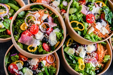 Yuvarlak karton kutular ve önceden paketlenmiş sebze salataları satışa hazır.