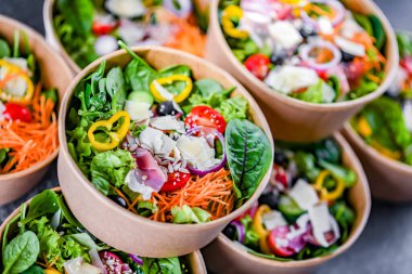 Yuvarlak karton kutular ve önceden paketlenmiş sebze salataları satışa hazır.