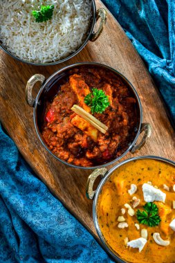 Hint yemekleri ile kompozisyon: medras paneer, palak paneer ve shahi paneer ile orijinal Hint karahi kaplarında servis edilen basmati pilavı