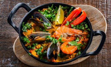 Seafood paella served in a cast iron pan.