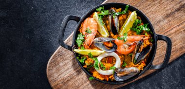 Seafood paella served in a cast iron pan.