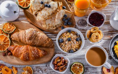 Breakfast served with coffee, orange juice, scrambled eggs, cereals, pancakes and croissants.