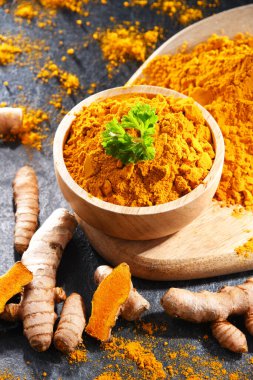 Bir kase zemin zerdeçal ve taze rhizomu ile kompozisyon.