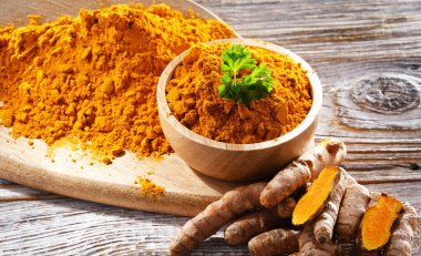 Bir kase zemin zerdeçal ve taze rhizomu ile kompozisyon.