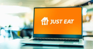 POZNAN, POL - 22 Kasım 2022: Hollanda merkezli Just Eat Takeaway.com 'un çevrimiçi gıda siparişi ve dağıtım markası Just Eat' in logosunu gösteren dizüstü bilgisayar