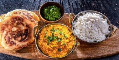 Hint karahi kaplarında servis edilen pirinçli körili tavuk..