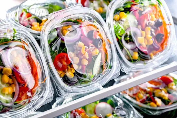 市販の冷蔵庫で販売のために置く 事前にパッケージ化された野菜サラダ付きのプラスチックボックス — ストック写真