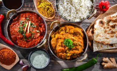 Hot madras paneer and vegetable masala with basmati rice served in original indian karahi pots.