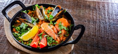 Seafood paella served in a cast iron pan.