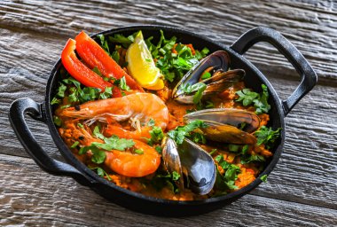 Seafood paella served in a cast iron pan.