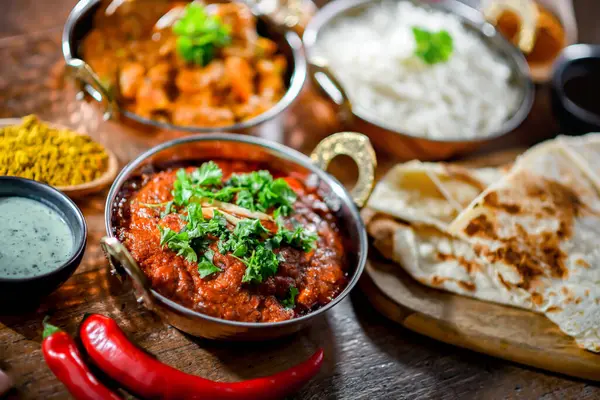 Hot madras paneer and vegetable masala with basmati rice served in original indian karahi pots.